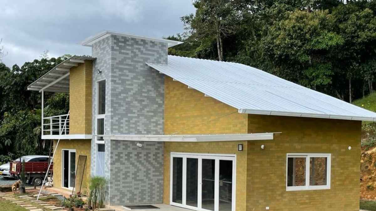 Casa construida con ladrillos ecológicos Plock hechos de plástico reciclado en zona rural rodeada de vegetación
