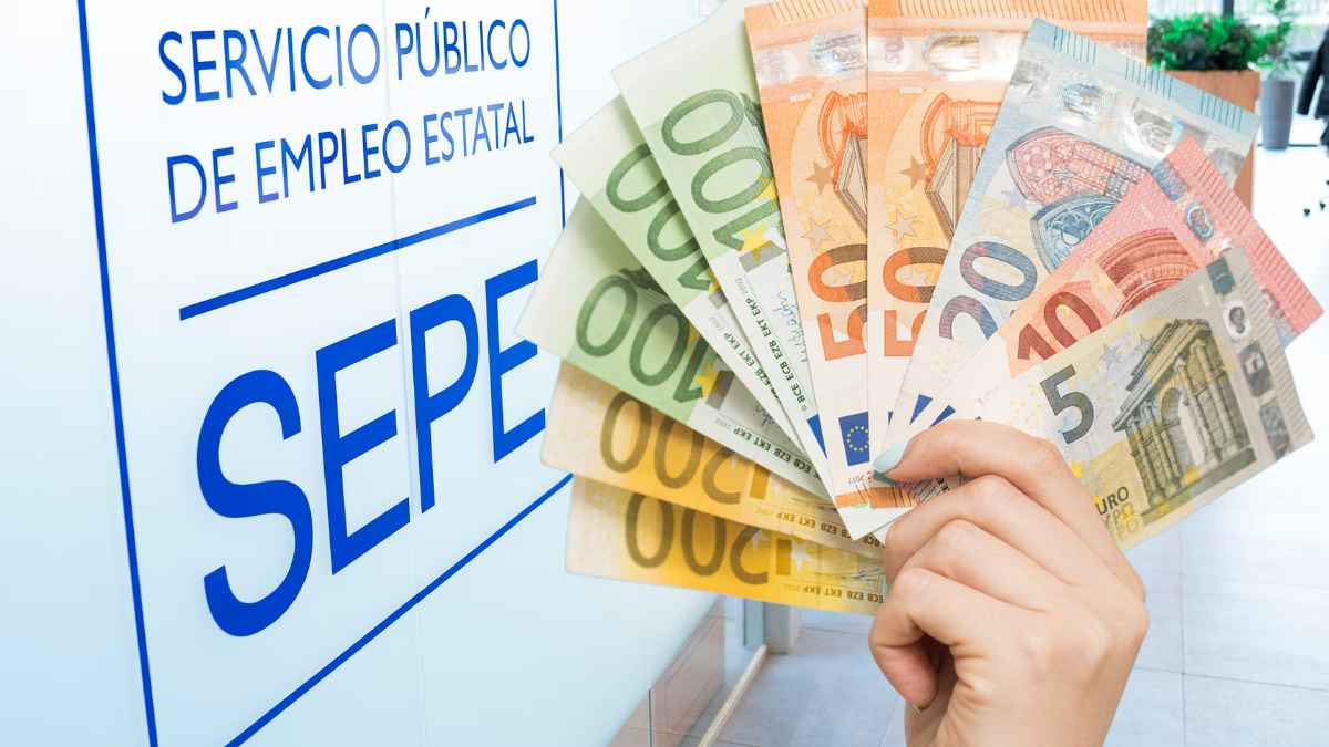 Billetes de euro frente a un cartel del SEPE por el nuevo subsidio de 570 euros para personas sin derecho a paro