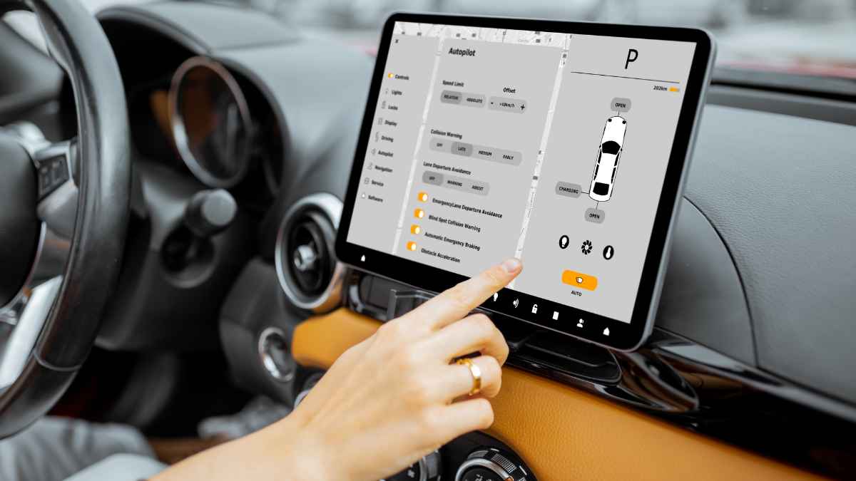 Mano usando la pantalla táctil central de un coche para ajustar funciones del vehículo