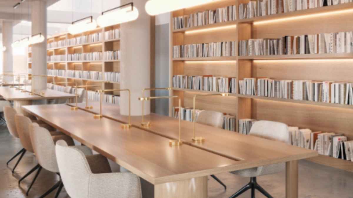 Sala de estudio moderna en biblioteca con estanterías llenas y mesas de trabajo iluminadas