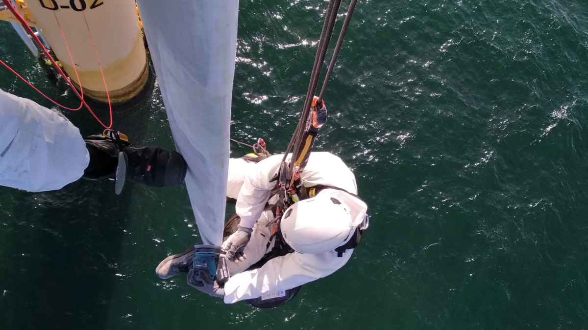 Trabajadores realizando labores técnicas en altura sobre el mar con equipos de seguridad en una plataforma offshore