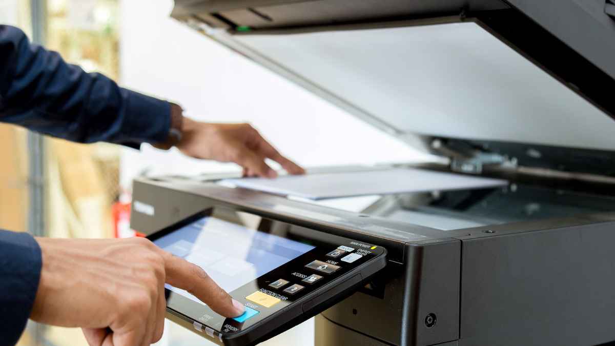 Persona usando una fotocopiadora para reproducir documentos en un alojamiento que solicita copias del DNI sin base legal