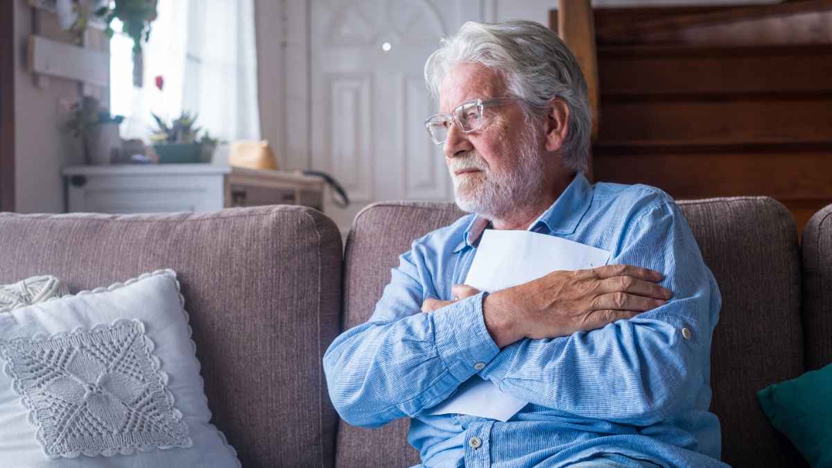 Hombre mayor con documentos en las manos preocupado por su pensión