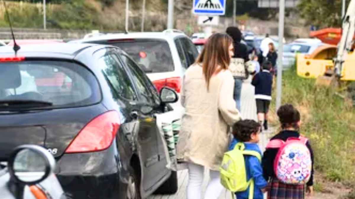 Madres y niños caminando hacia el colegio por una carretera en Andalucía ante la falta de transporte escolar