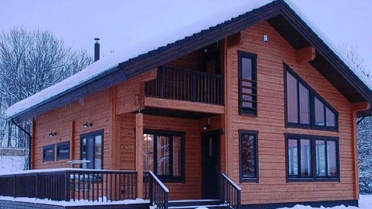 Casa prefabricada de madera con dos plantas y terraza cubierta en un entorno nevado