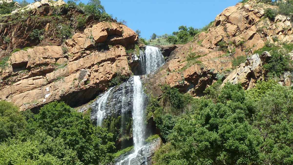 Formación rocosa con cascada que ilustra antiguos paisajes fluviales relacionados con la acumulación natural de oro
