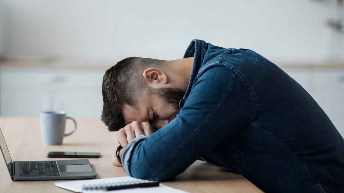 Empleado agotado en su puesto de trabajo tras largas jornadas laborales antes de una baja médica
