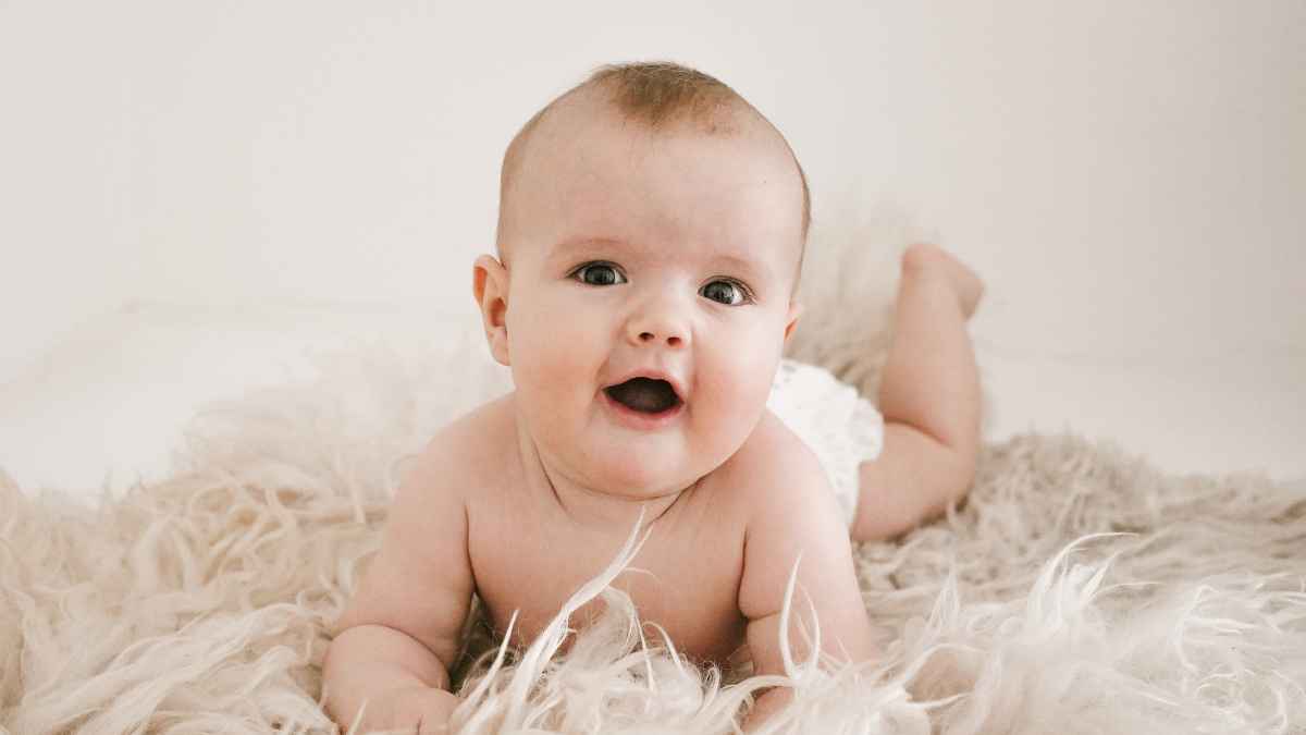 bebé tumbado sobre manta clara representando permiso por nacimiento y dos semanas adicionales de la seguridad social