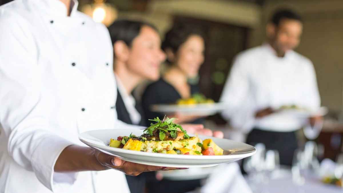 Camareros sirviendo platos en una taberna durante un servicio de hosteleria