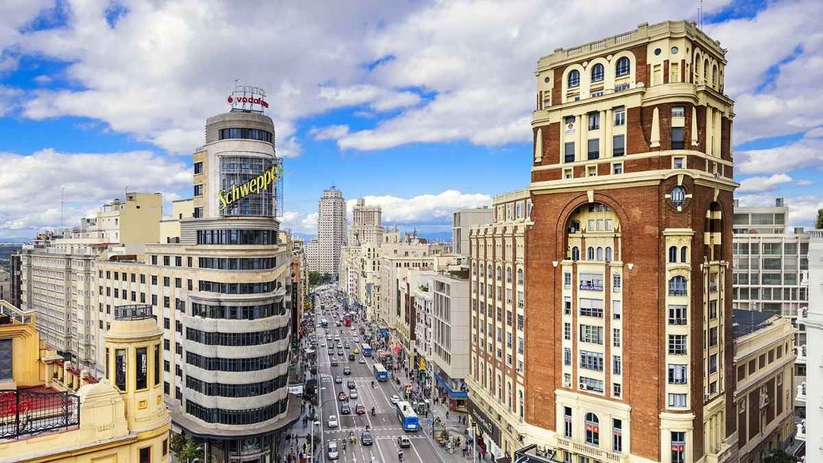 Vista de la Gran Vía de Madrid con edificios emblemáticos y tráfico diario, reflejo del alto coste de vida en la capital