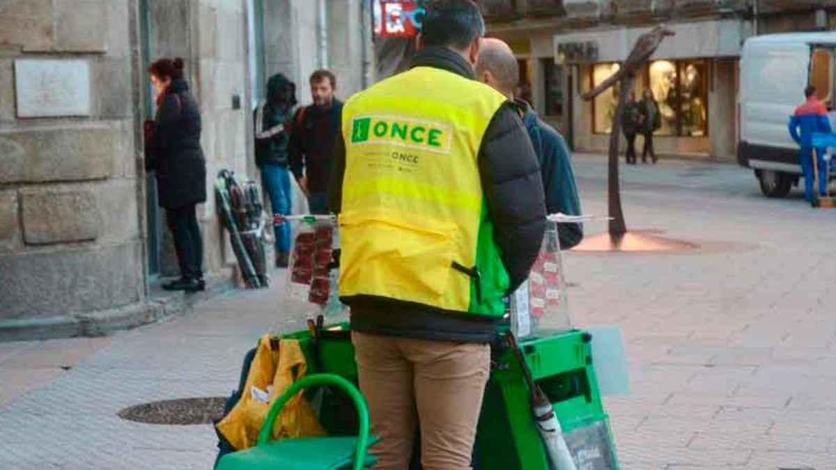 Vendedor de la ONCE atendiendo su puesto en la calle con chaleco identificativo