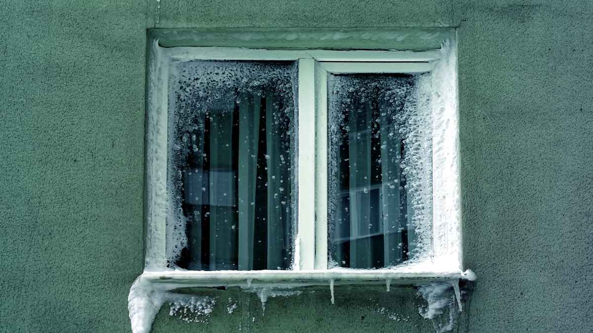 Ventana con escarcha por el frío, señal de filtraciones de aire y pérdida de calor en casa