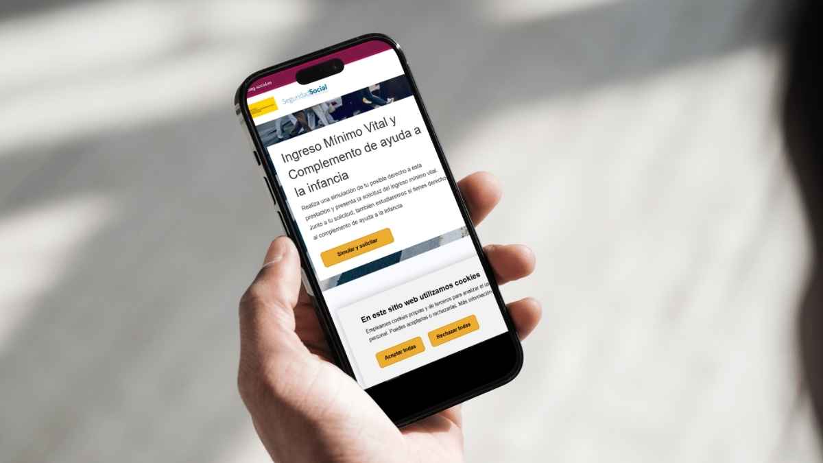 Móvil mostrando la web de la Seguridad Social para solicitar el Ingreso Mínimo Vital y el complemento de ayuda a la infancia
