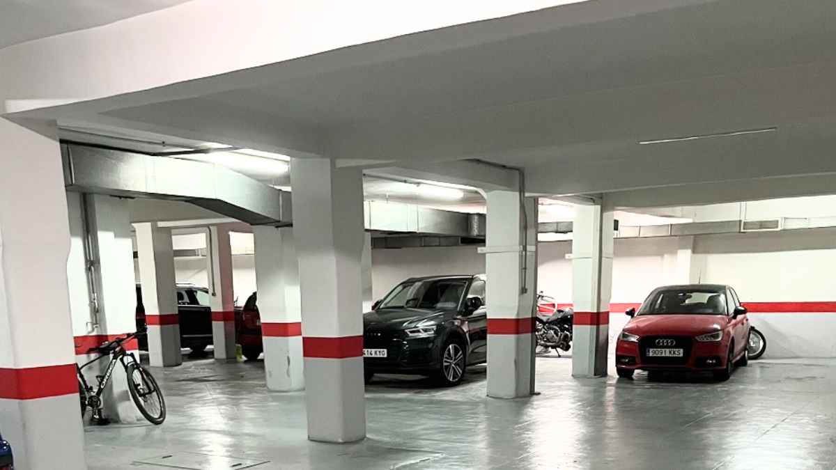 Garaje comunitario con varias plazas de aparcamiento y coches, afectado por la nueva tasa de basuras según el Catastro