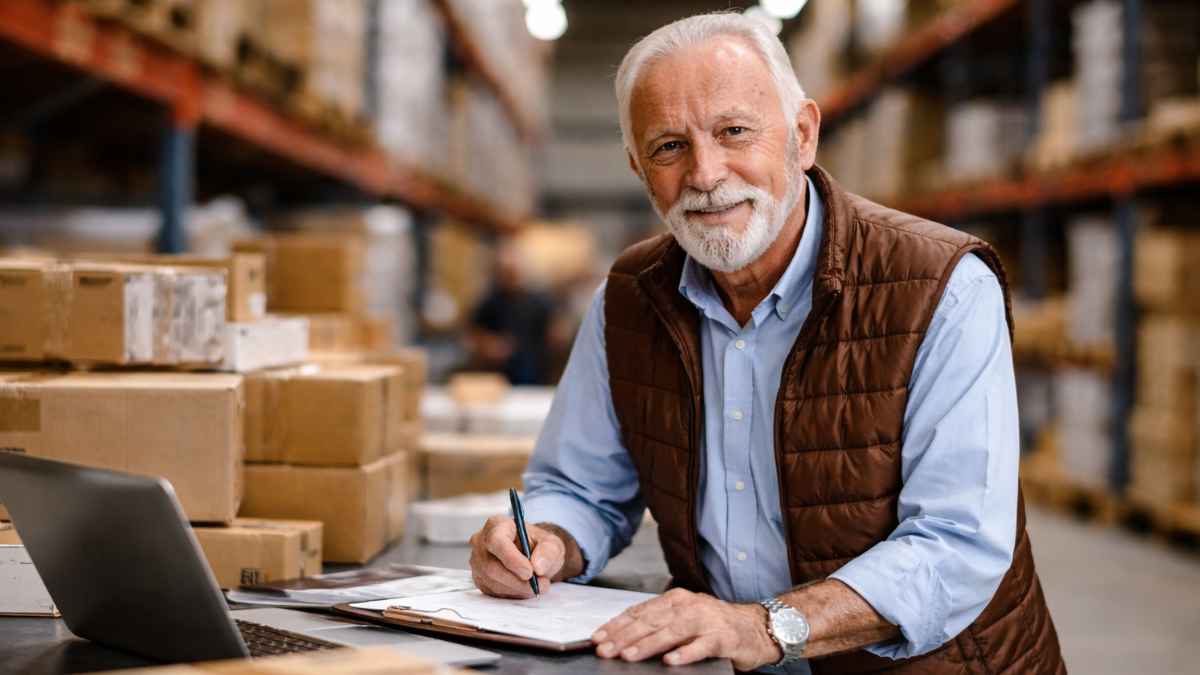 Hombre de 86 años trabajando en un almacén y gestionando pedidos en su empresa
