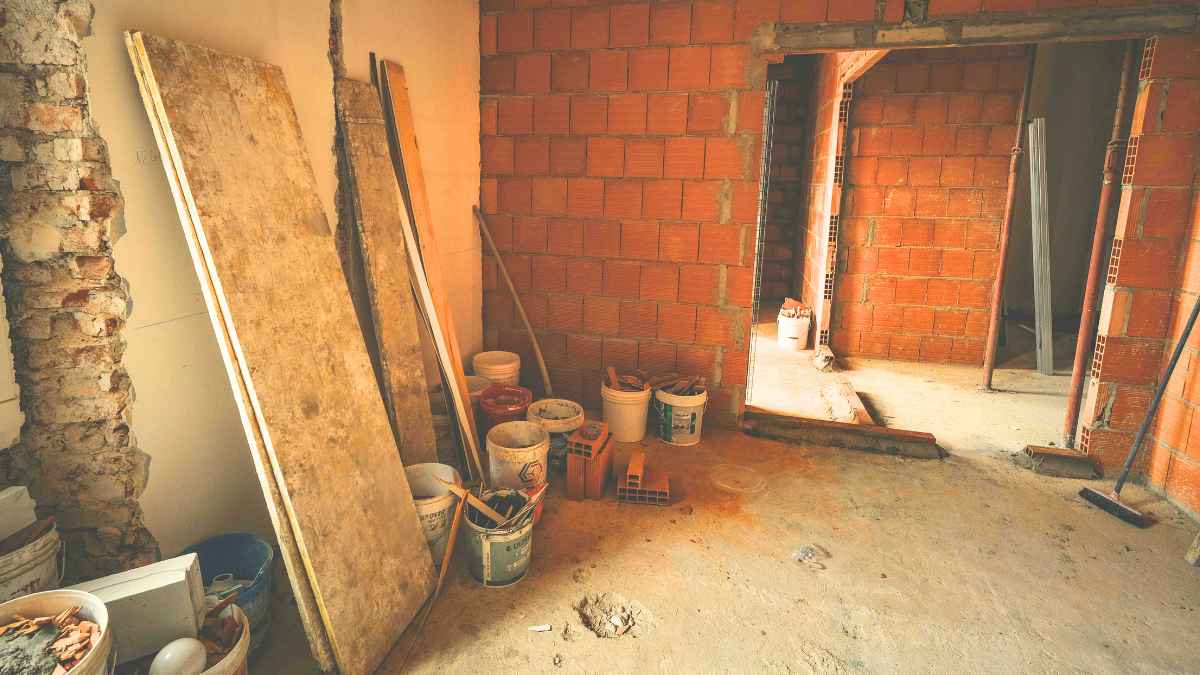 Obras en una vivienda con paredes de ladrillo visto y materiales de reforma, ejemplo de reforma en casa en una comunidad de vecinos