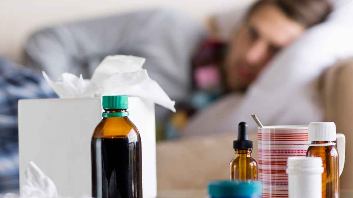 Trabajador de baja laboral en cama con medicamentos durante una incapacidad temporal
