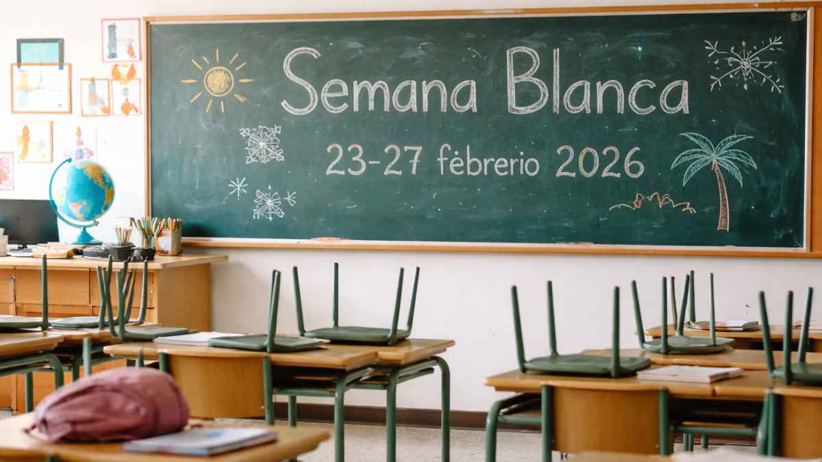 Aula de primaria vacía con sillas sobre las mesas y una pizarra que anuncia la Semana Blanca en Málaga del 23 al 27 de febrero de 2026.