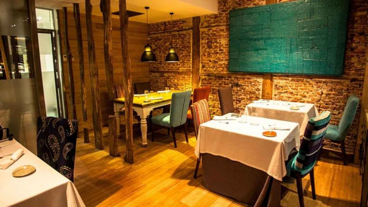 Interior del restaurante Lúa en Madrid con mesas vestidas y decoración de ladrillo visto antes de su cierre definitivo