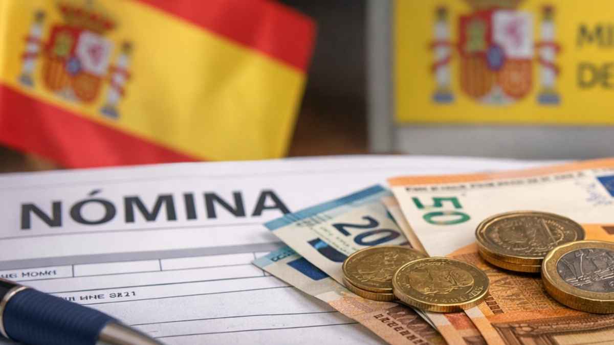 Nómina con billetes y monedas de euros junto al cartel del Ministerio de Hacienda, ilustrando la retención de 43 euros al mes a quienes cobran el SMI