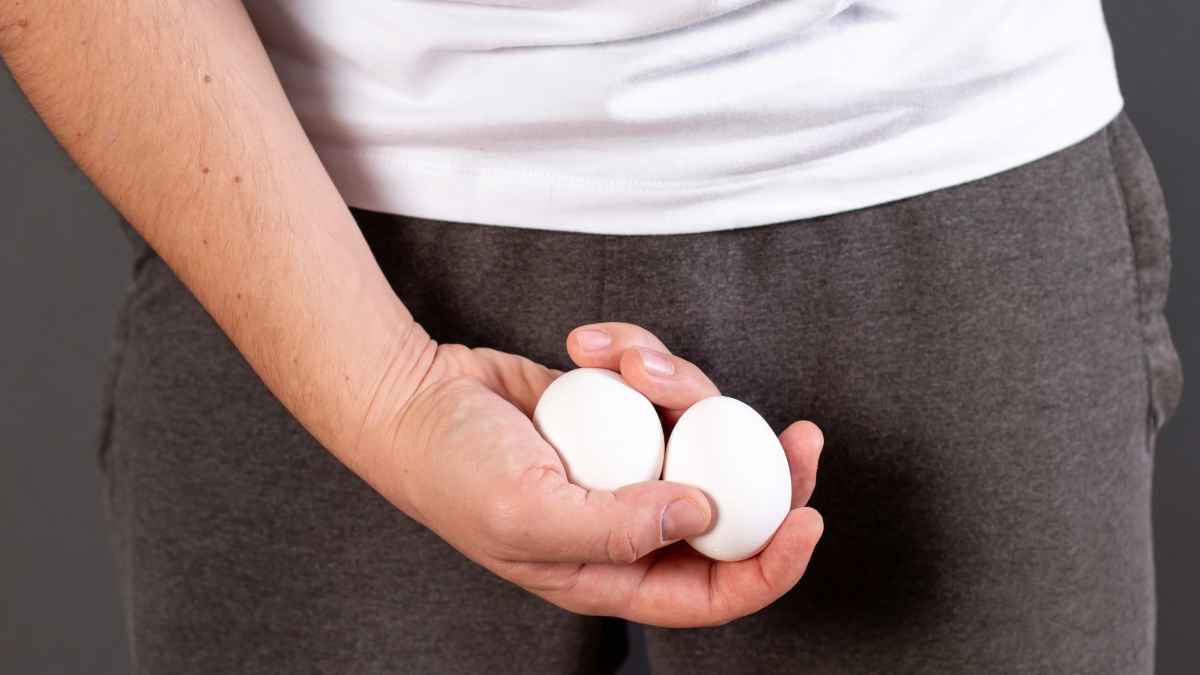 Persona sujetando dos huevos a la altura de la ingle en alusión a la inflamación de testículos durante una baja médica