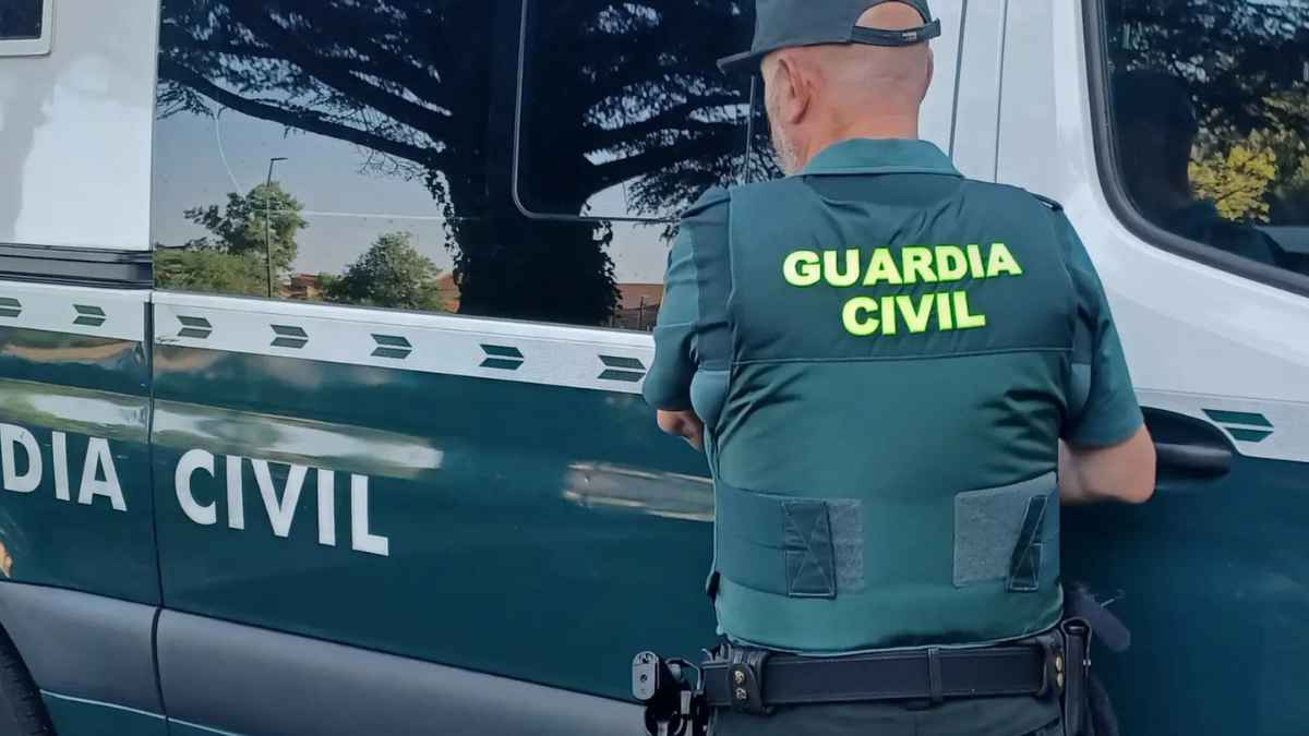 Agente de la Guardia Civil junto a un vehículo oficial en la alerta por correos falsos que suplantan a la DGT y reclaman multas inexistentes