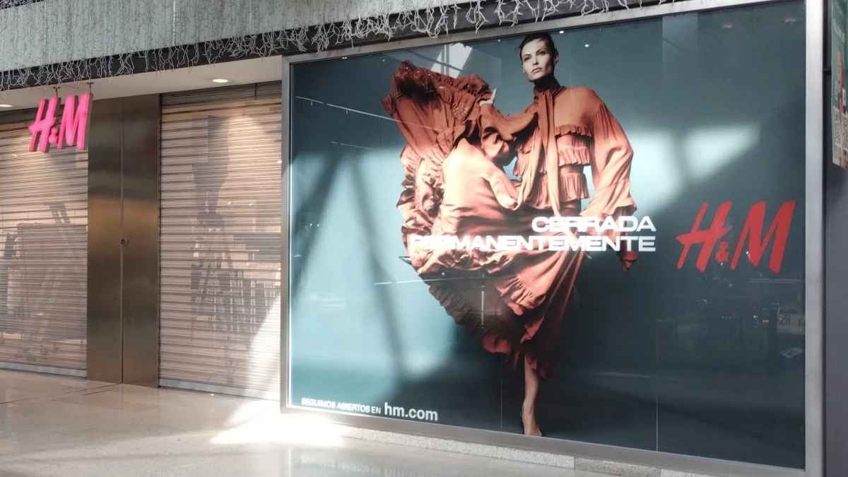 Tienda de H&M en centro comercial con persiana bajada y cartel de cerrada permanentemente dentro de su plan de cierres de locales