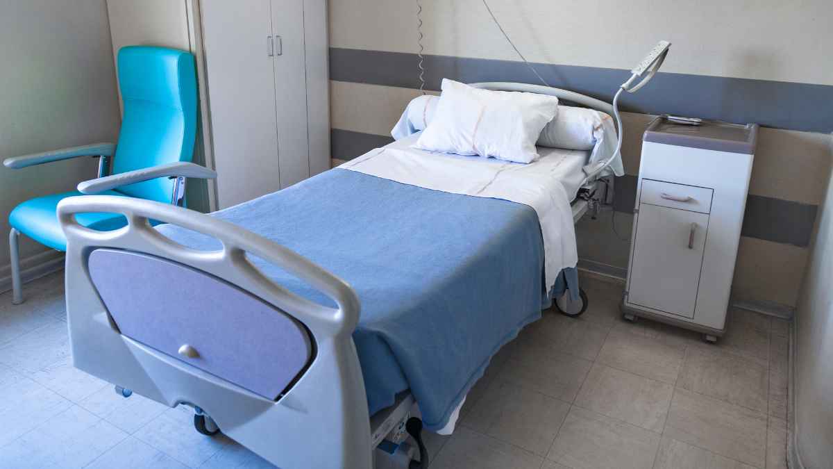 Habitación de hospital con cama y sillón, relacionada con el permiso retribuido por hospitalización de un familiar