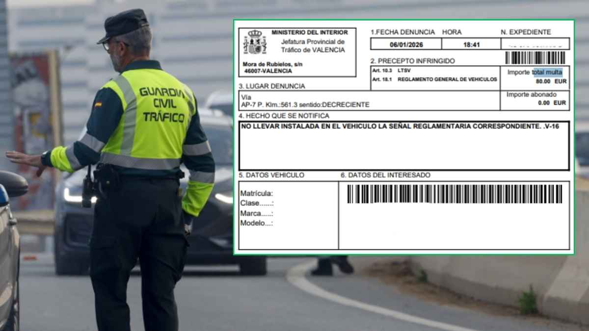 Agente de la Guardia Civil Tráfico durante un control en carretera junto a una multa de 80 euros por no llevar la baliza V-16 obligatoria