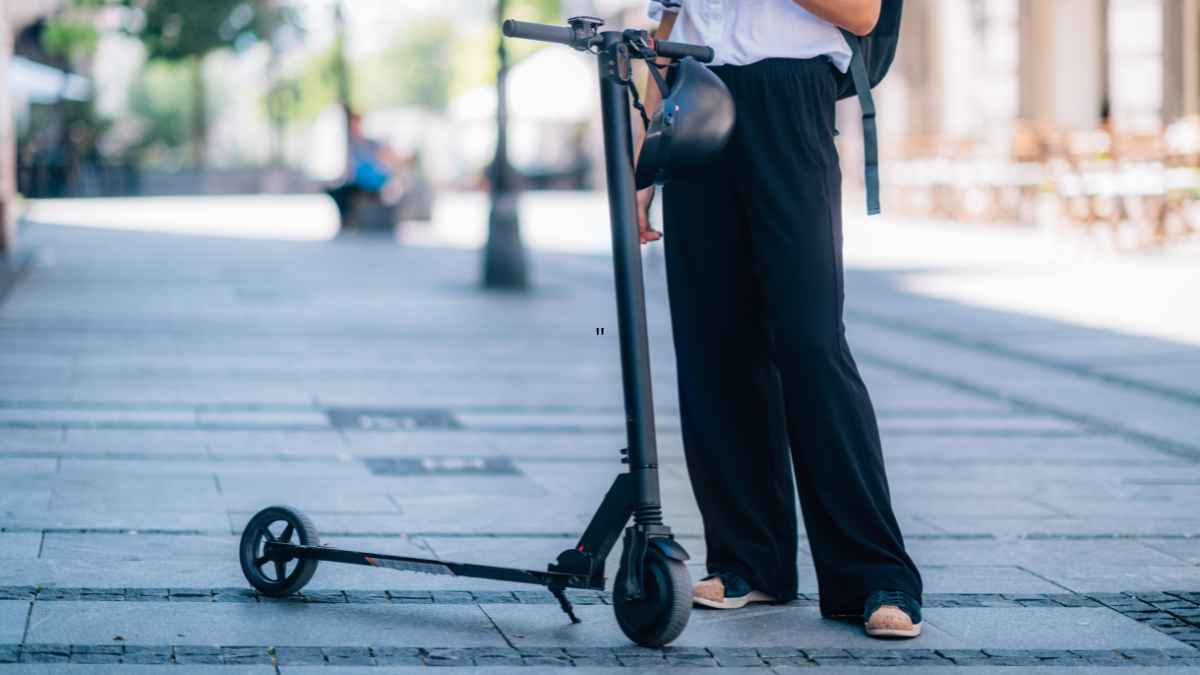 Joven con patinete eléctrico en la calle tras las nuevas normas de la DGT sobre VMP y multas de hasta 800 euros