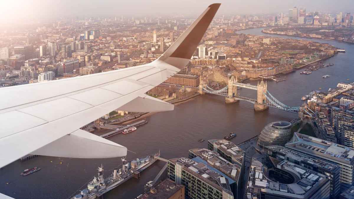 Vista aérea de Londres desde la ventanilla de un avión, con el ala sobre el río Támesis y el Tower Bridge, en un viaje al Reino Unido.