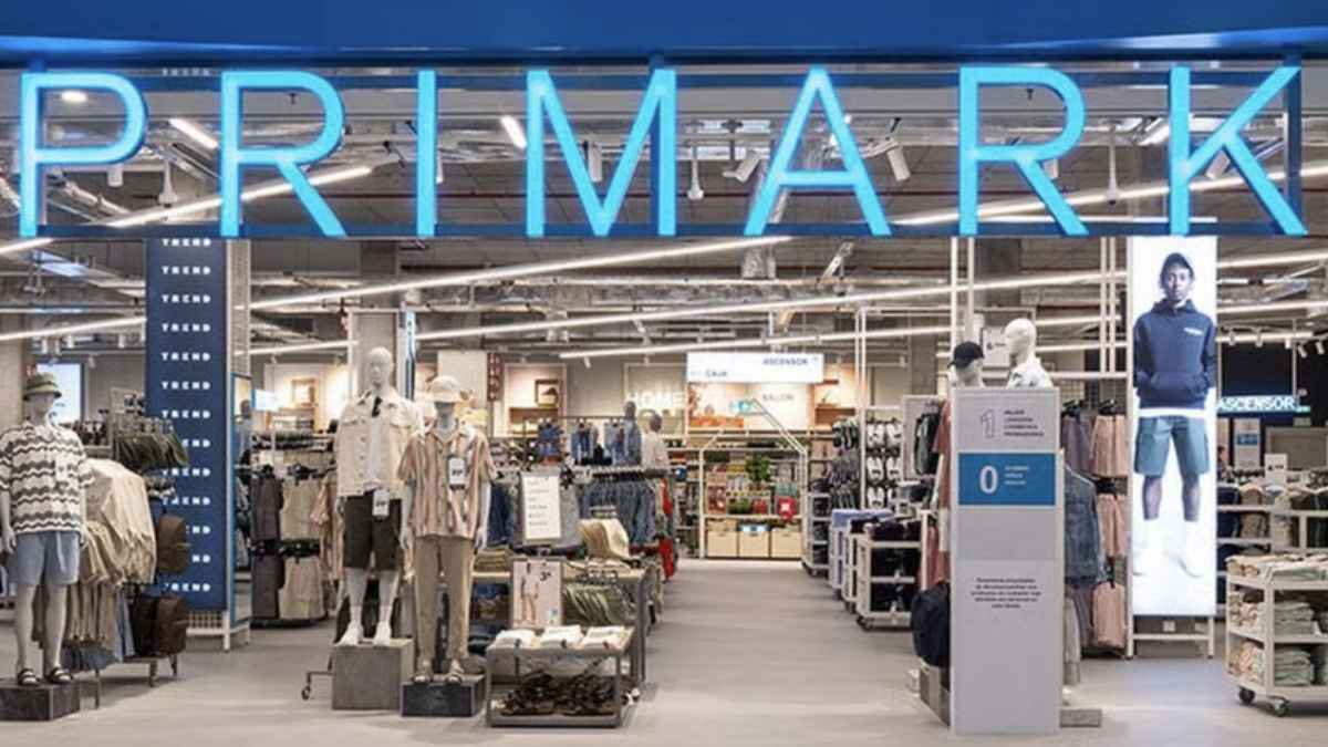 Entrada de una tienda Primark con maniquíes y letrero luminoso en azul