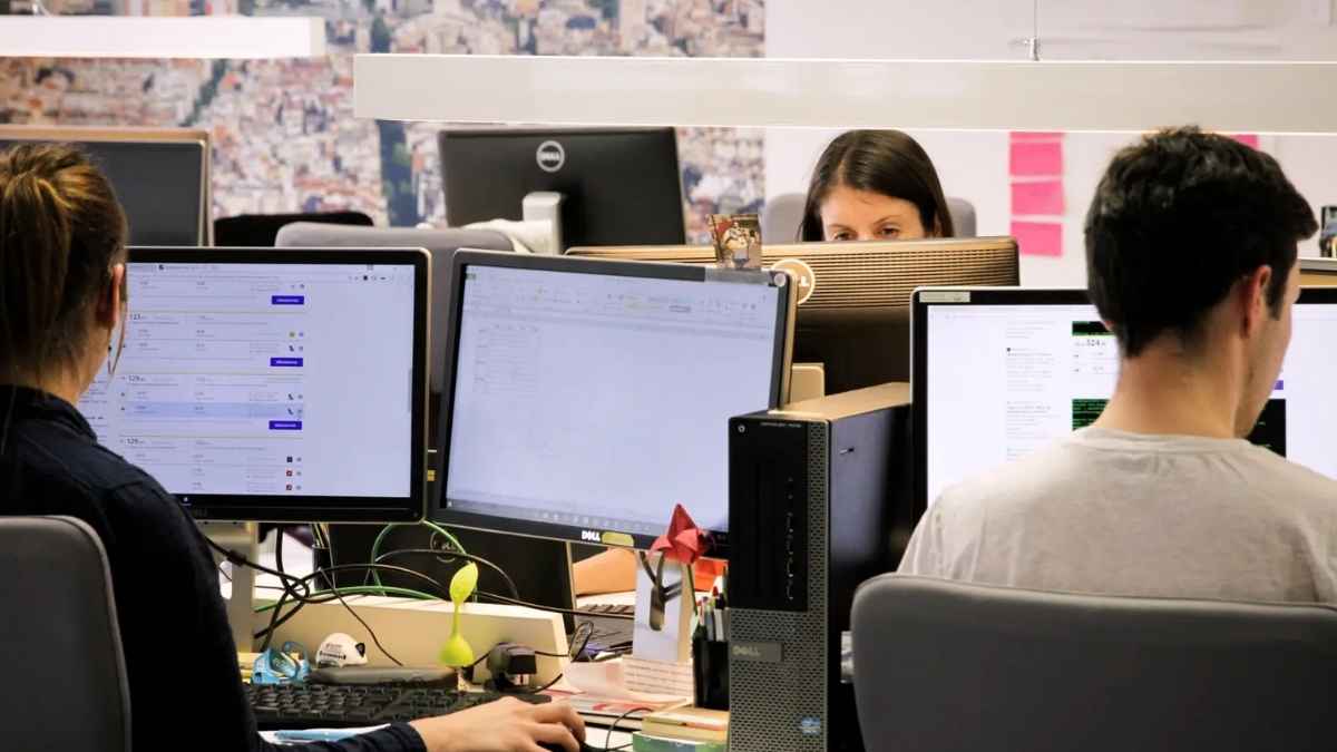 Personas trabajando en oficina frente a ordenadores en el sector comercial y tecnológico