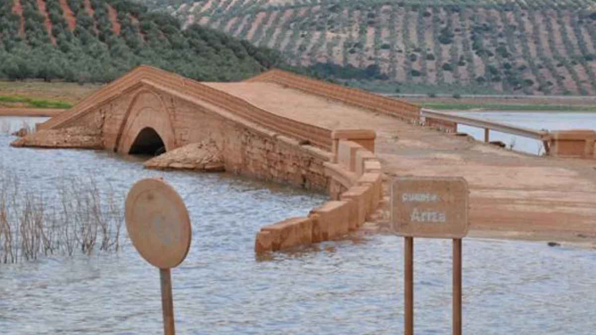 Puente parcialmente inundado por la crecida del río tras las fuertes lluvias en Andalucía