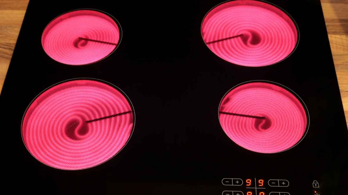 Placa vitrocerámica encendida con cuatro zonas de cocción al rojo, imagen para un artículo sobre alternativas más eficientes