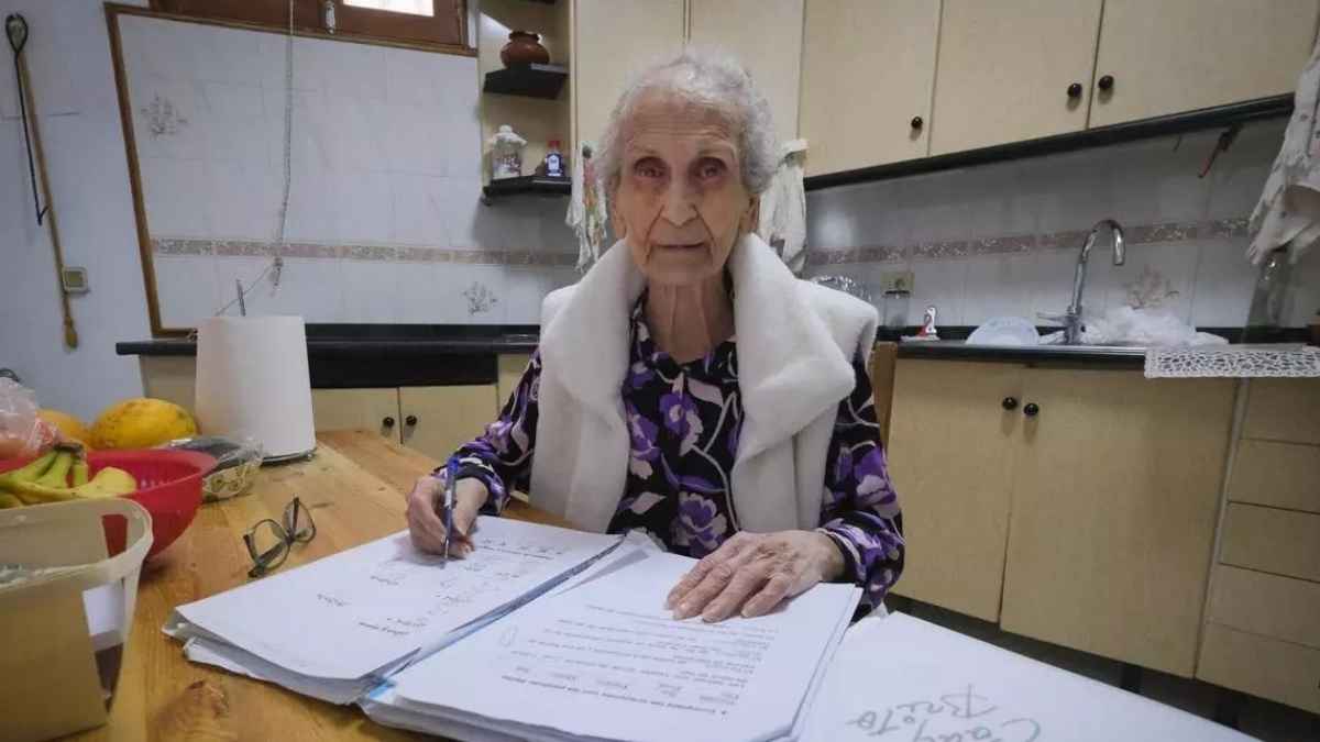 Lola, de 92 años, estudia en casa con apuntes y cuaderno sobre la mesa mientras continúa su formación.