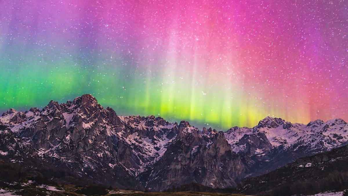 Auroras boreales sobre los Picos de Europa con cielo rosa y verde durante una noche despejada en España