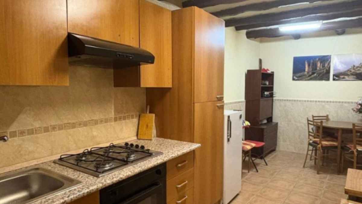 Cocina amueblada de la casa adosada que CaixaBank vende en Ayerbe, Huesca, por 23.800 euros