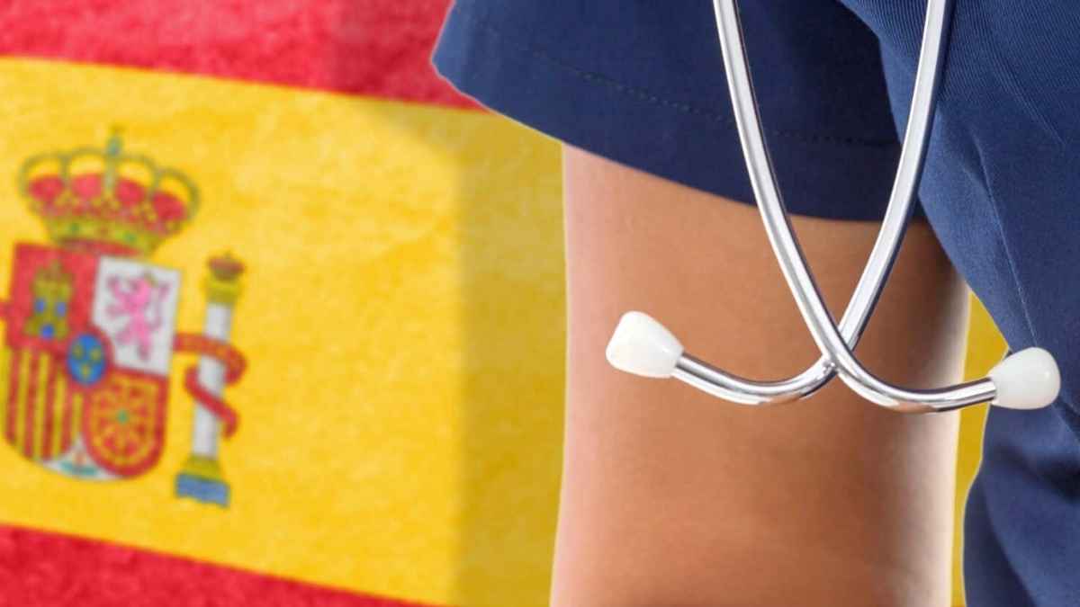 Profesional sanitario con fonendoscopio delante de la bandera de España, imagen sobre el coste de las bajas laborales