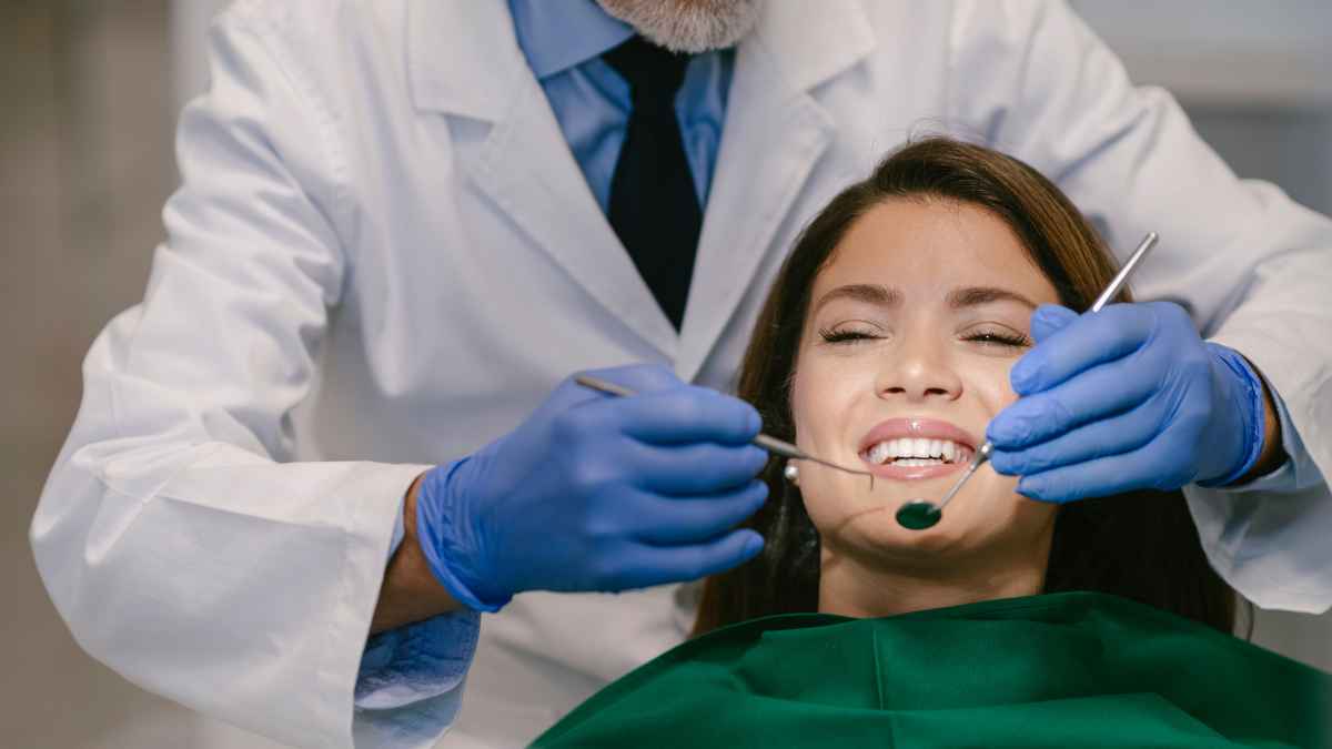 Dentista realizando tratamiento bucodental a una paciente, imagen relacionada con deducciones fiscales por gastos sanitarios en la Comunidad Valenciana.
