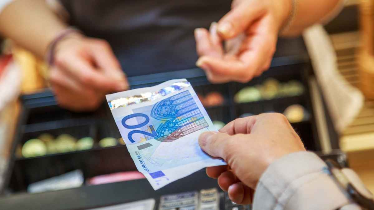 Cliente pagando en efectivo en un supermercado tras el límite fijado por Hacienda