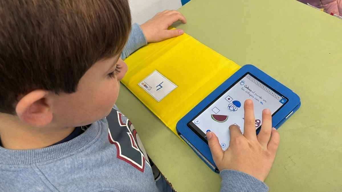 Niño de Primaria usando una tablet educativa en clase con actividades de aprendizaje digital e Inteligencia Artificial