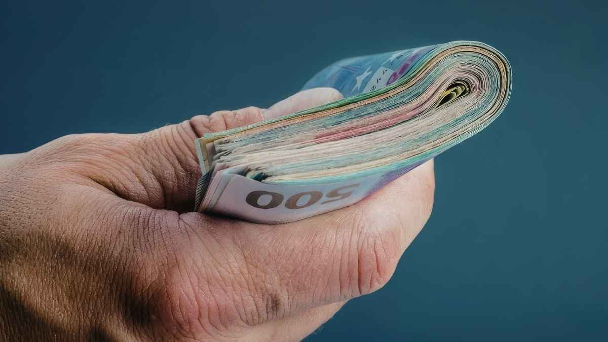 Mano sujetando billetes de euro, imagen sobre devolución de 17.143,29 euros por cobro de pensión de jubilación e incapacidad temporal