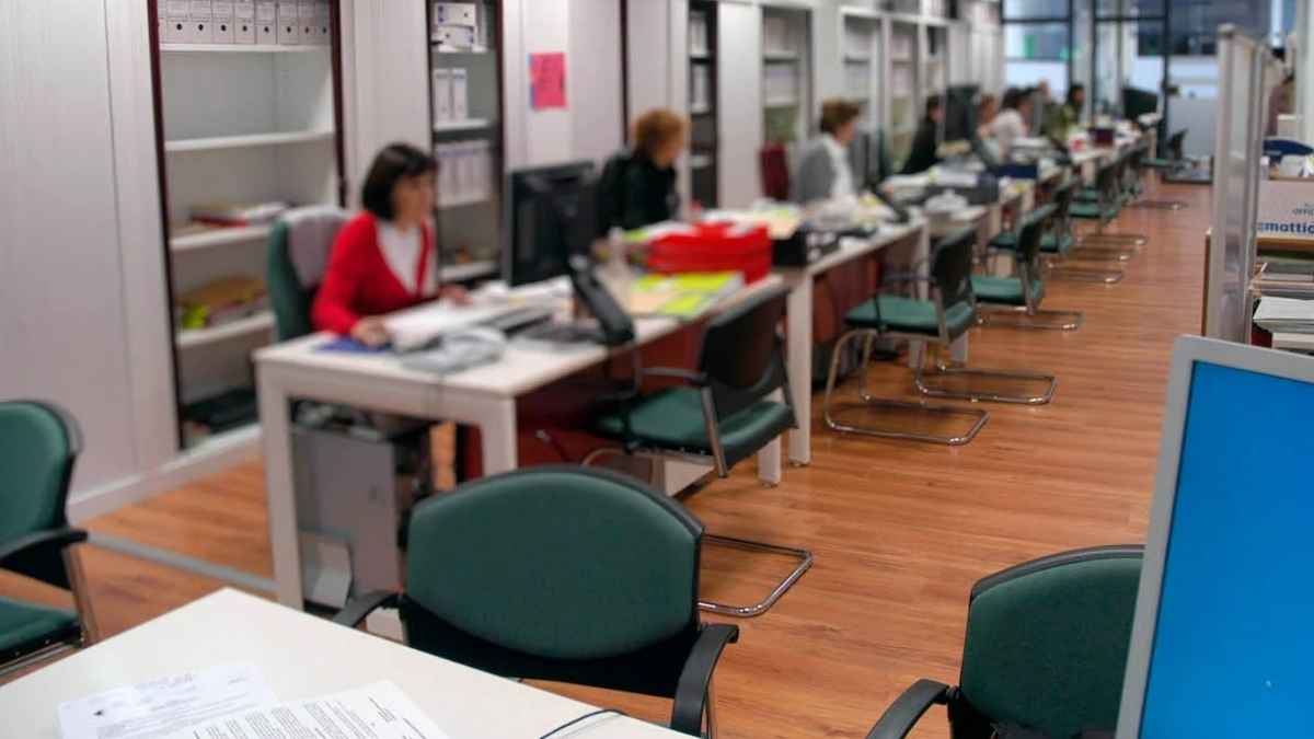 Oficina de la Seguridad Social con empleados atendiendo al público en mesas de gestión administrativa