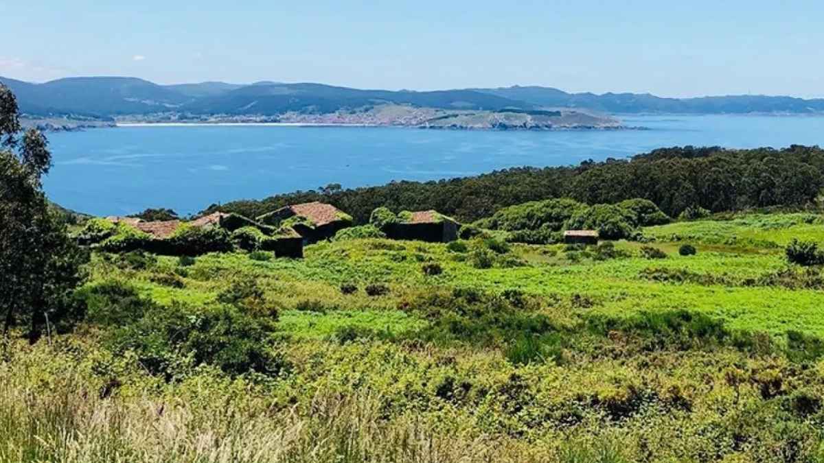 Aldea de Galicia en venta con varias casas entre vegetación y vistas al mar