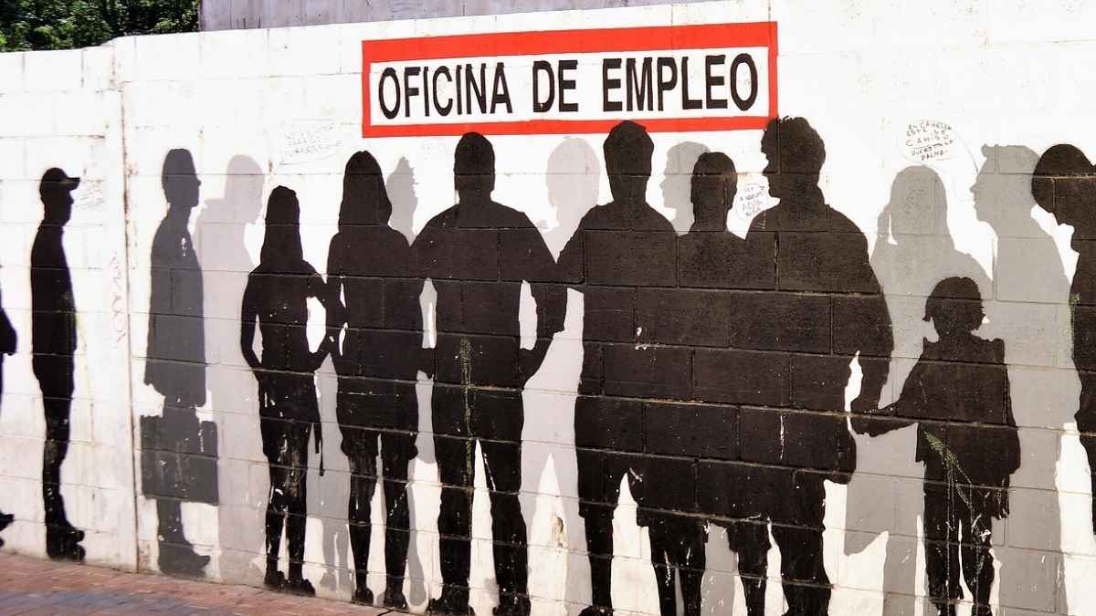 Personas en fila en una oficina de empleo, imagen sobre prestaciones del SEPE y el requisito de carencia de rentas