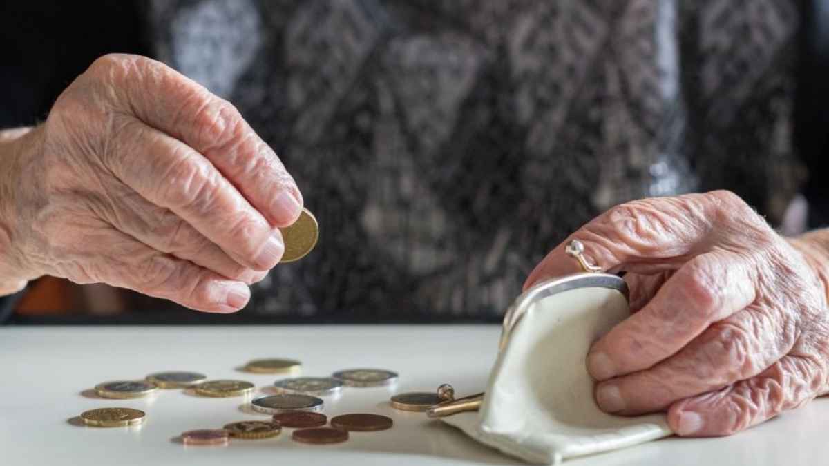 Manos de persona mayor contando monedas por retrasar la jubilacion y aumentar la pension
