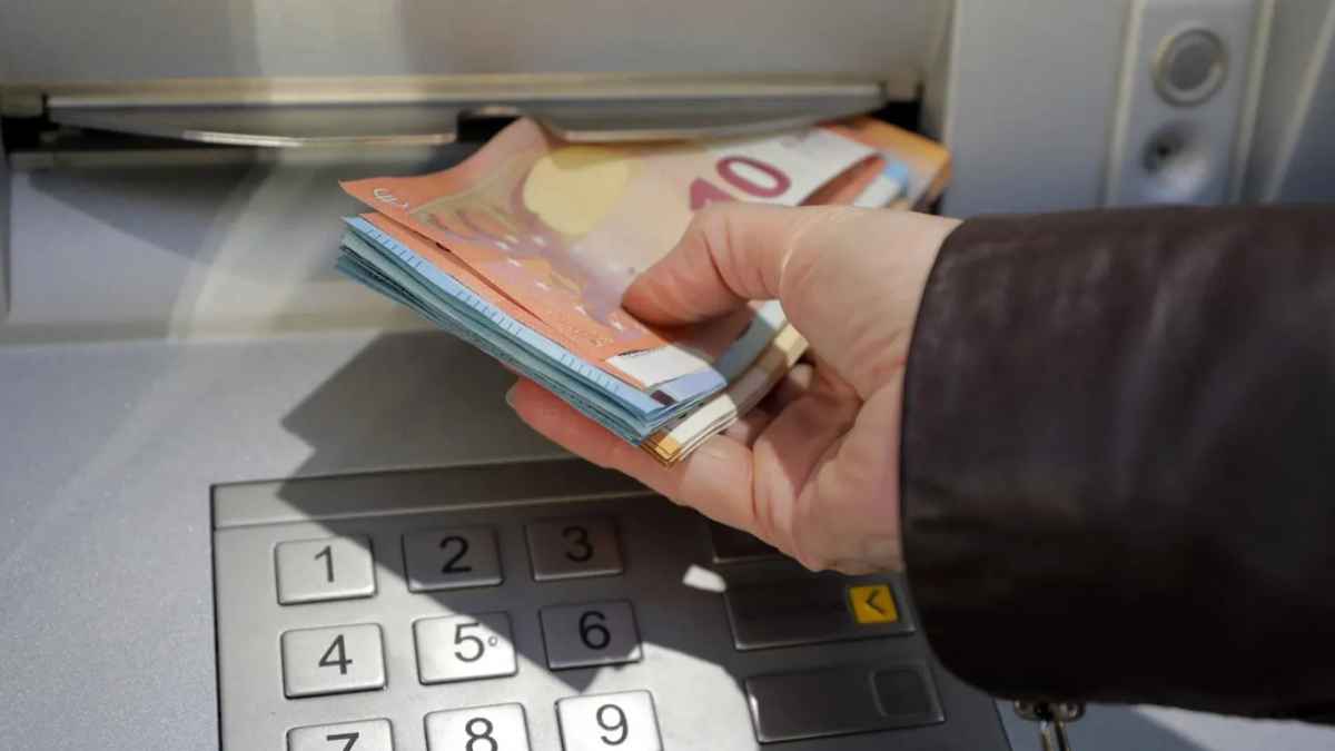 Persona sacando billetes de 10 euros de un cajero automático, reflejando el riesgo de retirar dinero de la cuenta de un enfermo antes de su fallecimiento.
