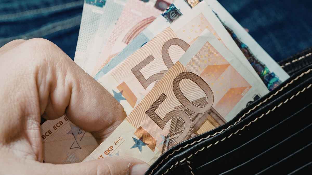 Billetes de euro en una cartera para ilustrar el cobro de ayudas públicas y prestaciones