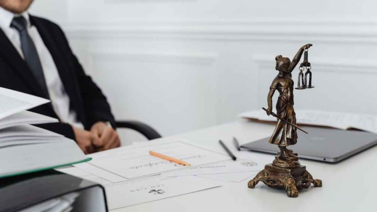 Estatua de la Justicia sobre una mesa de despacho en una noticia sobre despido improcedente y periodo de prueba